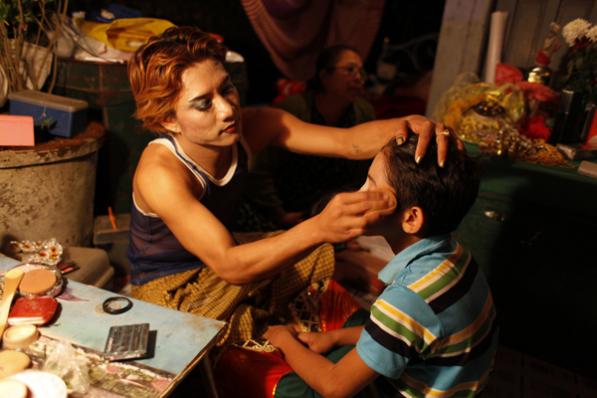 Zat Pwae dancers helping eachother apply make up before their dancing duty starts in Mudon, Mon State. Photo: Hong Sar