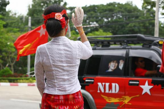 (File) Myanmar's de-facto leader Aung San Suu Kyi wearing a facemask and gloves, to halt the spread of the COVID-19 coronavirus, waves to supporters of her National League for Democracy (NLD) party as they drive past in Naypyidaw on September 19, 2020. Photo: AFP