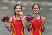 Image: Gold medallists Zou Jiaqi and Qiu Xiuping of China celebrate their win / Photo: AFP