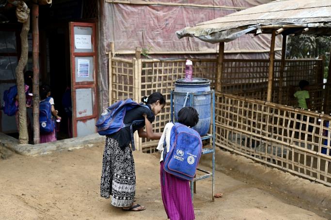 In this picture taken on March 27, 2022, Rohingya refugee children collect drinking water in a school in Kutupalong refugee camp in Ukhia. Photo: AFP