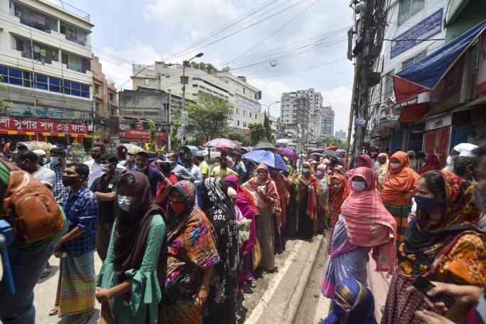 People wait in queues to buy groceries from a government-subsidized shop in Dhaka on July 6, 2021. Photo: AFP