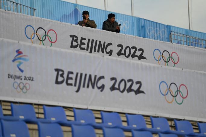 Men use their mobile phones at the spectator area of the Shougang Big Air venue, which will host the big air freestyle skiing and snowboarding competitions at the Beijing 2022 Winter Olympics, at the Shougang Park in Beijing. Photo: AFP