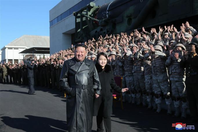 An undated photo released by the official North Korean Central News Agency (KCNA) on 27 November 2022 shows North Korean leader Kim Jong-un (C-L) walking with his daughter, presumed to be his second child, Ju-ae (C-R), during a photo session with the contributors to the successful test-fire of new-type ICBM Hwasongpho-17 at an undisclosed location in North Korea. Photo: EPA