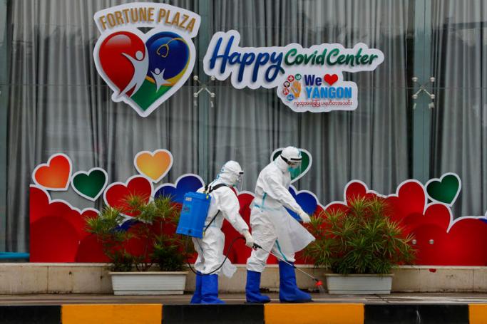 People wearing PPE (Personal protective equipment) spray disinfectant outside of a COVID-19 center in Yangon, Myanmar, 08 October 2020. Photo: EPA