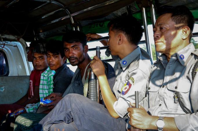 (File) Rohingya men escorted by armed policemen sit in a light truck at the KyaukTan township, south of Yangon, Myanmar, 16 November 2018. Photo: EPA