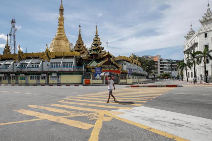 A man crosses the empty road near Sule pagoda at downtown area in Yangon. Photo: EPA