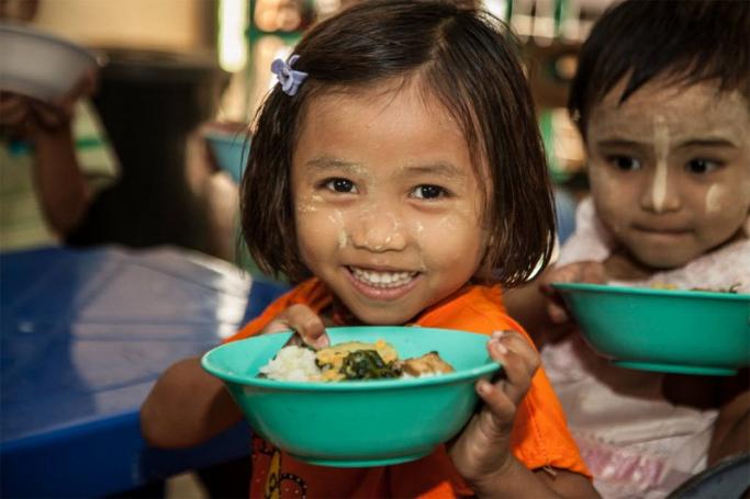 A girl in Myanmar is fed a meal after her mother received training in nutrition and hygiene from World Vision. Photo: World Vision 
