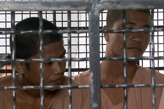 The Myanmar migrant workers who are accused of the killing of two British tourists, Wai Phyo (L) and Zaw Lin Oo (R), sit behind the bars of a prison vehicle as they arrive for trial at court on Samui island, Surat Thani province, Thailand, December 8, 2014.  Photo: Sitthipong Charoenjai/EPA
