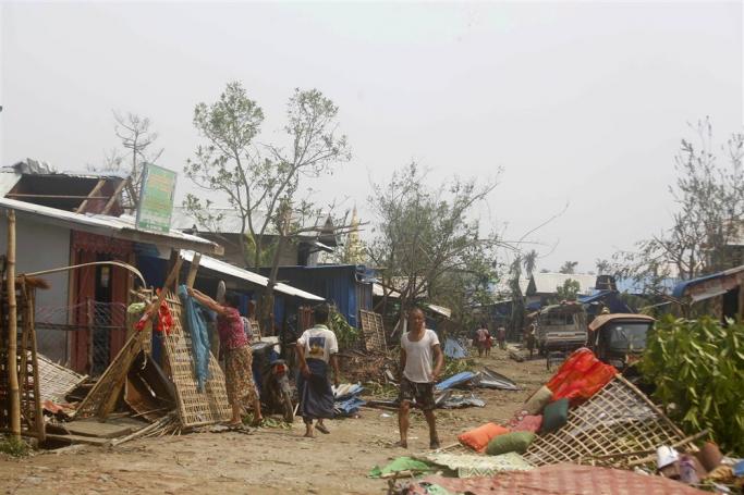 People walk among the debris after cyclone Mocha made landfall in Sittwe, Rakhine State, Myanmar, 15 May 2023. Photo: EPA
