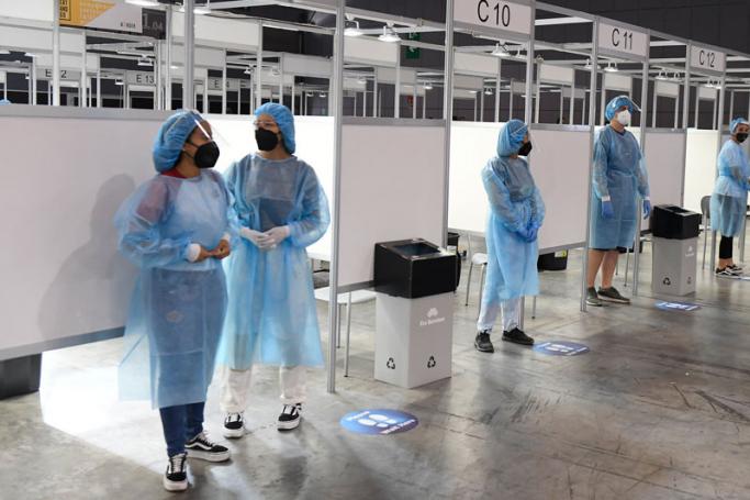 Healthcare workers wait for visitors to take Covid-19 tests at the Mobile World Congress (MWC) fair in Barcelona on June 28, 2021.  Photo: AFP