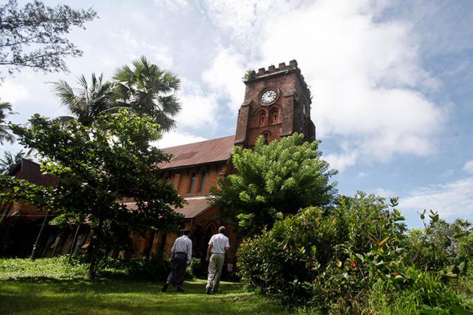 A Burmese man leading a foreign visitor into an old church (constructed in 1887 during British colonial time) in Mawlamyine, Mon State, Myanmar, 05 July 2013. Photo: Lynn Bo Bo/EPA

