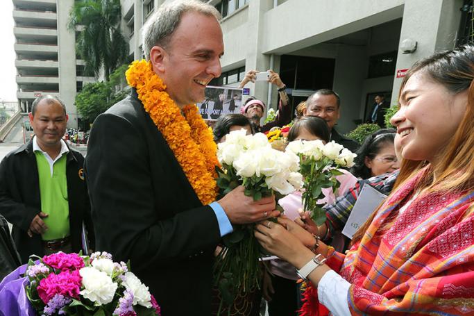 British migrant workers’ rights activist, Andy Hall (C) receives flowers from supporters as he arrives for a hearing at the Bangkok South Criminal Court in Bangkok, Thailand, 20 September 2016. Photo: Narong Sangnak/EPA
