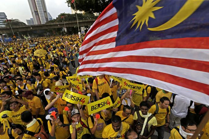 Malaysian protestors hold up a national flag and banners with the rally logo reading 'Bersih', meaning clean in the Malay language, as they march on the city streets during a BERSIH (The Coalition for Free and Fair Elections) rally in Kuala Lumpur, Malaysia, 29 August 2015.EPA/RITCHIE B.TONGO
