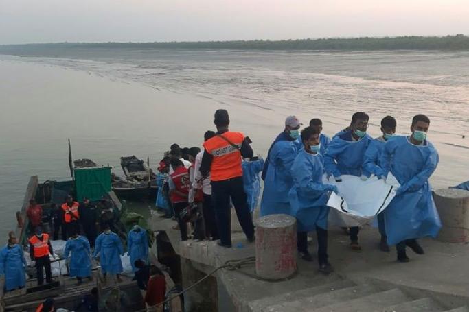 Rescue workers carry a dead body (R) following a boat capsizing accident, in Teknaf on February 11, 2020. Photo: AFP
