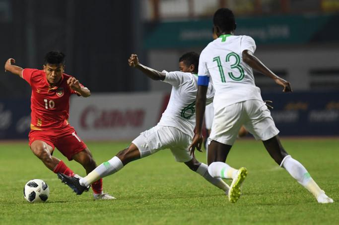 Myanmar's Aung Thu (L) fights for the ball with Saudi Arabia's Yousef Saad Alharbi (C) and Abdullah Hassun Tarmin (R) during the men's football Group F match between Saudi Arabia and Myanmar at the 2018 Asian Games at Cikarang on August 17, 2018. Photo: AFP