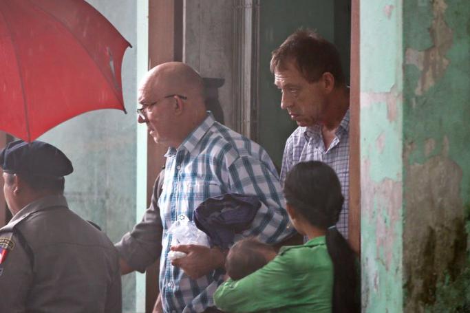 Australian publisher Ross Dunkley (C-L) followed by his partner John McKenzie (C-R) leaves the court after the first appearance on his trial at Bahan township court in Yangon, 15 June 2018. Photo: Lynn Bo Bo/EPA-EFE
