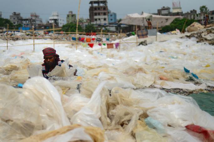 A Bangladeshi woman arranges plastic bags to dry and recycle in Dhaka. Photo: AFP