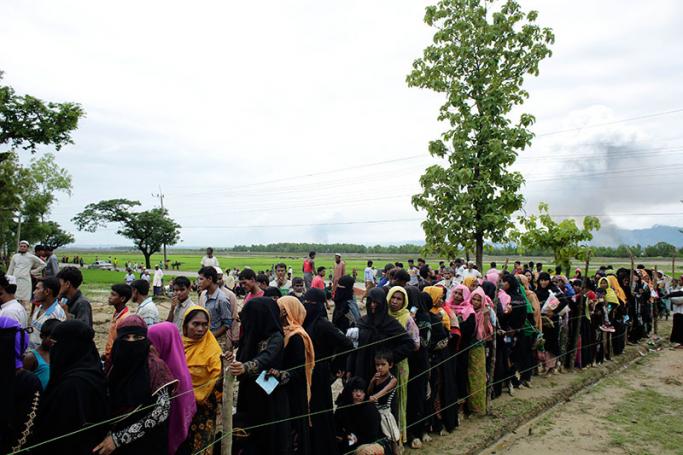Rohingya refugees in a queue as they wait to receive aid relief in Teknaf, Bangladesh, 10 September 2017. Photo: Abir Abdullah/EPA-EFE
