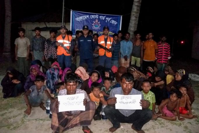Bangladesh Coast Guard pose for a photo with rescued Rohingya refugees in Teknaf on May 31, 2019. Bangladesh coast guard have rescued 58 fortune seeking Rohingya refugees in a Malaysia-bound fishing trawler near the coast of the country's southern island in Bay of Bengal, officials said on May 30, 2019. Photo: Suzauddin Rubel/AFP