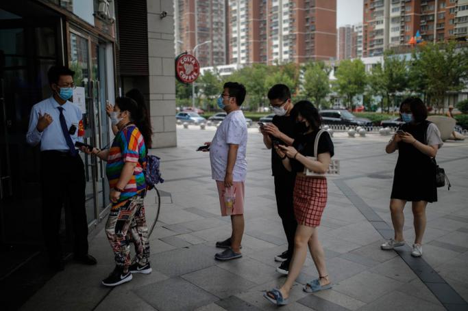 People wearing protective face masks queue to show their health QR code to enter a shopping mall on the Chinese traditional holiday of Dragon Boat Festival, amid coronavirus pandemic in Beijing, China, 25 June 2020. Photo: EPA