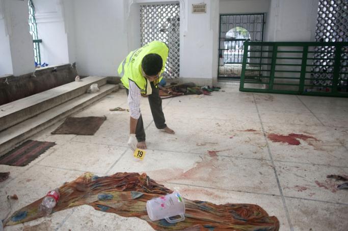 A security official inspects the scene of a bomb blast at Hoseni Dalan in Dhaka, Bangladesh, 24 October 2015. Photo: EPA
