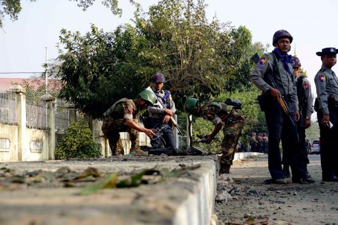 Soldiers and police officers inspect the site of a bomb explosion in Sittwe, Rakhine State, western Myanmar, 24 February 2018. Photo: Nyunt Win/EPA-EFE
