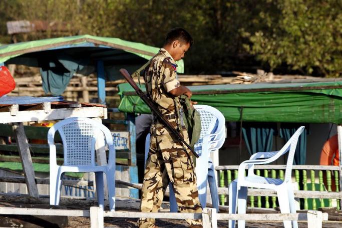 A border security guard prepares his equipment on the Sittwe Jetty, Sittwe, Western Myanmar. Photo: Nyein Chan Naing/EPA
