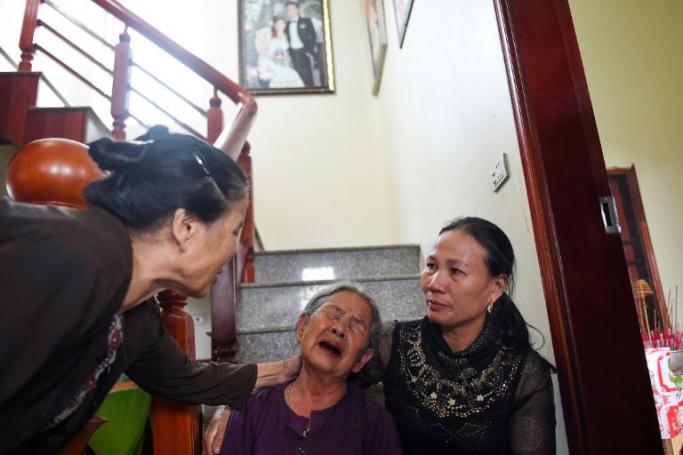 Tran Thi Hue (C), grandmother of 30-year old Le Van Ha, who is feared to be among the 39 people found dead in a truck in Britain, is consoled by relatives inside their house in Vietnam's Nghe An province. Photo: Nhac Nguyen/AFP