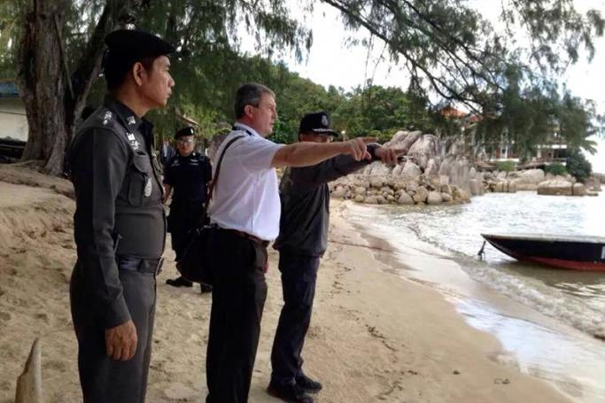 A British police officer (C) is accompanied by his Thai counterparts as they inspect the murder scene where two British tourists were murdered at Sairee beach, Koh Tao island, Thailand, October 25, 2014. The British police team including Scotland Yard officers visited Koh Tao island resort to observe an investigation by the Thai police. Photo: EPA 
