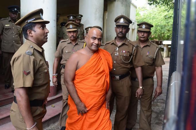 Sri Lankan guards escort Buddhist monk Akmeemana Dayarathana (C) after he was remanded in custody in Colombo on October 2, 2017, over his involvement in a violent attack on Rohingya refugees. The monk is accused of leading a violent attack on a UN-protected refugee centre at the Colombo suburb of Mount Lavinia and forcing the removal of 31 Rohingya, including 16 children, to a safer location. Photo: Lakruwan Wanniarachchi/AFP

