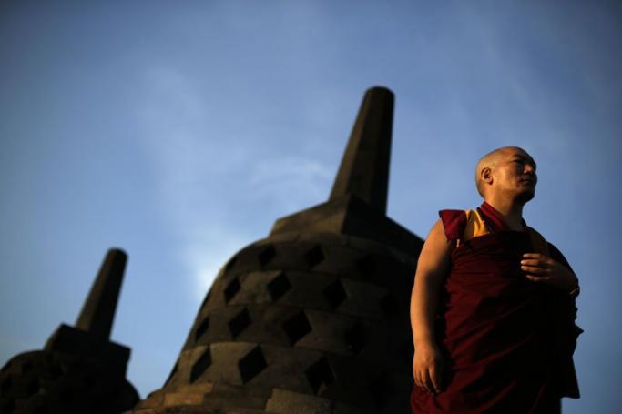 Buddhist monk stands near stupas at Borobudur Temple during a ritual on Vesak Day in Magelang, Central Java province, Indonesia, 25 May 2013. Photo: Mast Irham/EPA
