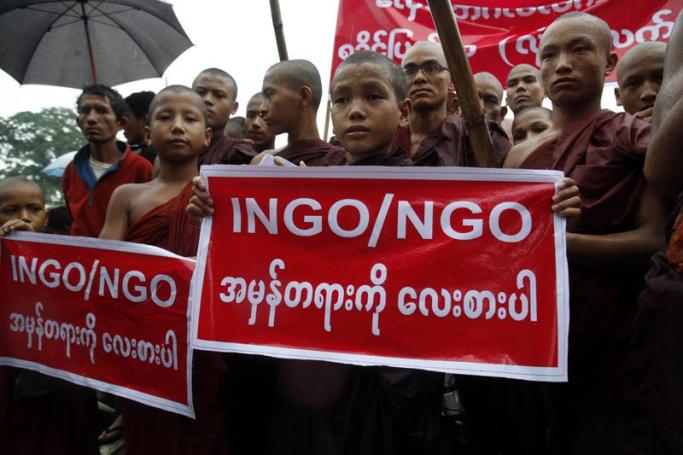 Young Buddhist novices hold the posters that read 'INGO/NGO respect the truth' during a protest against migrant boat people in Sittwe, Rakhine State, western Myanmar, 14 June 2015. Photo: Nyunt Win/EPA
