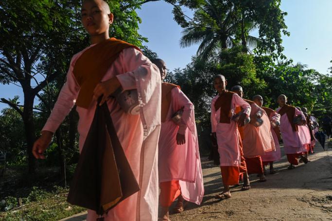 This photo taken on October 19, 2019 shows Buddhist nuns from the Mingalar Thaikti nunnery walking to collect alms in Yangon. Photo: Ye Aung Thu/AFP