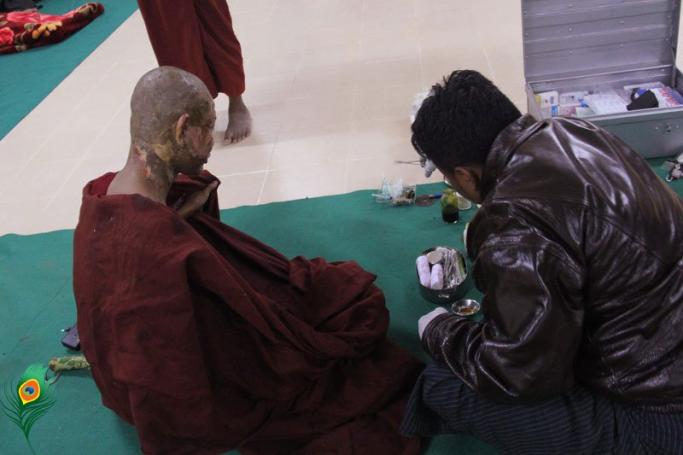 A Buddhist monk is treated for severe burns by a medic in Monywa in December 2012 following a police crackdown on protesters. PHOTO: Hein Htet/Mizzima
