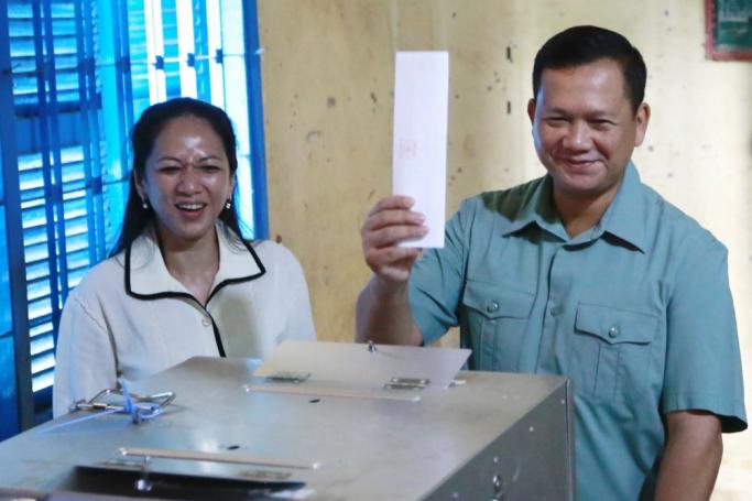 Hun Manet (R), Commander of the Royal Cambodian Army and eldest son of Prime Minister Hun Sen, displays his ballot while standing next to his wife Pich Chanmony (L), at a polling station in Phnom Penh, Cambodia, 23 July 2023. Photo: EPA