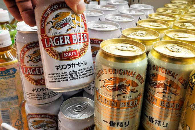 A customer picking up a can of Kirin beer at a liquor shop in Tokyo, Japan. Photo: EPA
