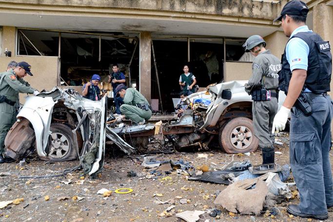 (File) Thai Explosive Ordnance Disposal (EOD) members and police officers inspect a damaged vehicle following a car bomb attack at a hotel in Tak Bai district of Narathiwat province, southern Thailand, 21 October 2012. Photo: EPA
