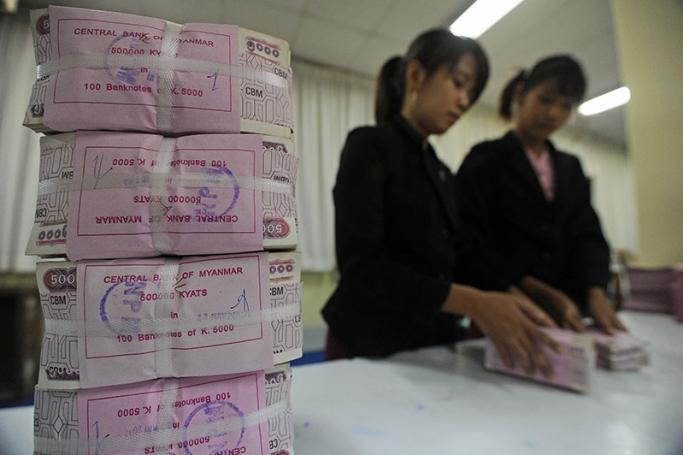 Myanmar employees handling bank notes at the central bank of Myanmar in Yangon. Photo: AFP
