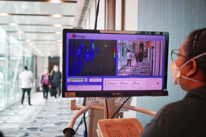A handout photo made available by Changi Airport shows a staff member screening the body temperatures of arriving passengers at the Changi Airport in Singapore, 22 January 2020. Photo EPA/ Changi Airport 