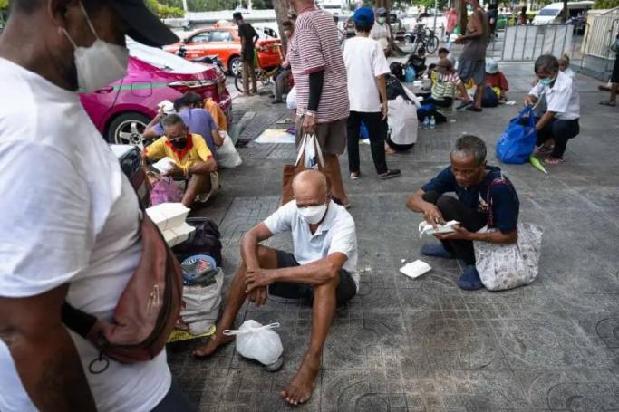 Senior citizens queuing up for daily food donations from Bangkok Community Help Foundation, near the Grand Palace in Bangkok on Sept 22. / Photo: AFP