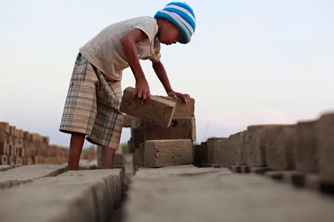 A child worker stacking bricks at a brick manufacturing site in Than Lyin, an outskirt township of Yangon region, southern Myanmar. Photo: Lynn Bo Bo/EPA
