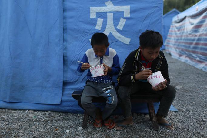 Myanmar refugees eating outside a tent at a refugee camp near the border of China and Myanmar in Wanding town, Ruili city of Yunnan province in southwest China, 21 November 2016. Photo: EPA
