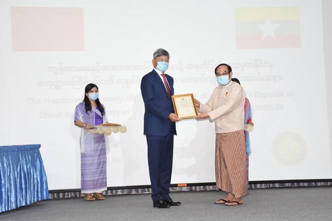 Union Minister Dr Myint Htwe (right) presents the certificate of honour to Chinese Ambassador Mr Chen Hai (centre) at the Ministry of Health and Sports in Nay Pyi Taw on 8 June 2020. Photo: MNA