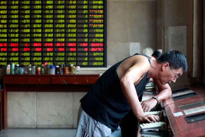 Investors monitor prices and make trades at a securities exchange house in Shanghai, China on 09 August 2011. Photo: Qilai Shen/EPA
