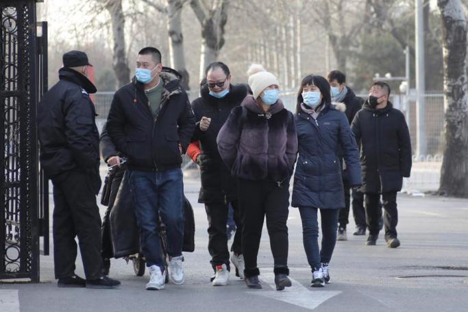 People wearing protective face masks walk near a temporary COVID-19 vaccine injection place outside the Chaoyang Park after they injected COVID-19 vaccines in Beijing, China, 03 January 2021. Photo: EPA
