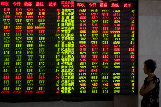 An investor watches stock price information in front of an electronic board at a securities exchange house in downtown Qingdao city, eastern China's Shandong province, China. Photo: Wu Hong/EPA
