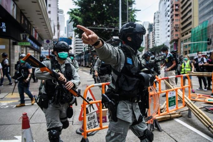 Riot police clear debris left by protesters attending a pro-democracy rally on May 24, 2020 against a proposed new security law China plans to impose on the territory (AFP Photo/ANTHONY WALLACE) 