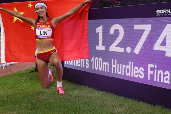 China's Lin Yuwei celebrates winning the women's 100m hurdles / Photo:AFP