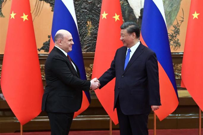 Russian Prime Minister Mikhail Mishustin (L) and Chinese President Xi Jinping shake hands during a meeting at the Great Hall of the People, in Beijing, China, 24 May 2023. Photo: EPA
