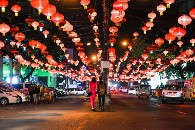 People walk under decorative lanterns ahead of the Chinese New Year in Yangon's Chinatown district on January 31, 2019. Photo: Ye Aung Thu/AFP